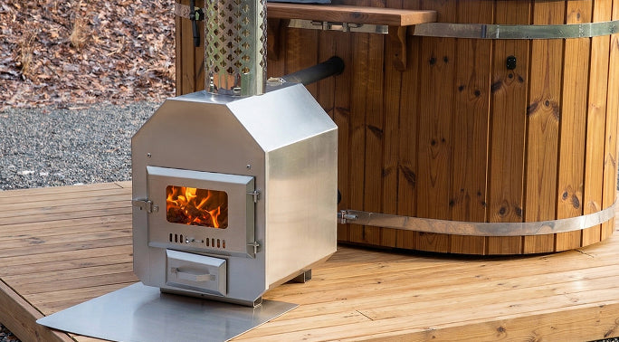 Wood-burning stove on a wooden deck with a hot tub in the background